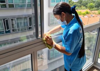 SEORANG pembantu rumah mencuci tingkap sebuah kediaman di Singapura.-AGENSI