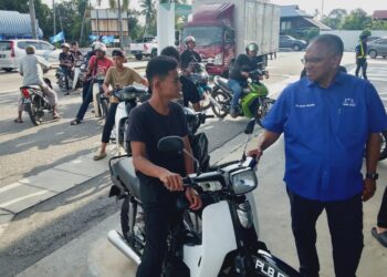 CALON BN kerusi DUN Sungai Dua, Shaik Hussein Mydin (kanan) menyantuni anak muda dalam jelajah kempen pada PRN di Sungai Lokan, Pulau Pinang semalam.