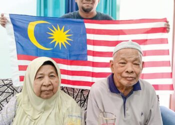 ABDULLAH Ismail sempat mengabadikan gambar kenangan bersama arwah isterinya, Zainap Abdul Jalil serta cucu, Ismail Badrulhisham bersama hadiah gelas wajah Tunku Abdul Rahman yang disimpan sejak 1957 di rumahnya di Segamat Baru, Segamat pada tahun lalu.