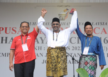 SUHAIZAN Kayat (kiri), Samsudin Mohamad Fauzi dan Zulkifli Jaafar mengangkat tangan selepas diumum calon PRK Parlimen Pulai. 
– MINGGUAN/RAJA JAAFAR ALI