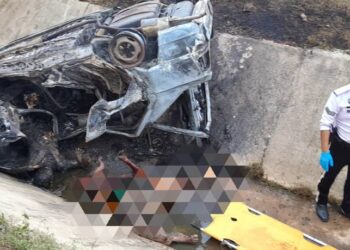 KEADAAN kereta yang terbabas dan terbakar menyebabkan empat rentung di WCE arah utara, dekat Ayer Tawar hari ini. - UTUSAN/JBPM PERAK