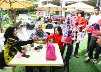 MESKIPUN baharu berusia 8 dan 5 tahun, namun dua beradik sudah menyemai semangat patriotisme dalam diri yang tinggi apabila mengambil inisiatif mengedar Jalur Gemilang kepada para pelanggan di The Bunker Cafe, Batas Liku di Arau, Perlis semalam.- UTUSAN/IZLIZAN OTHMAN