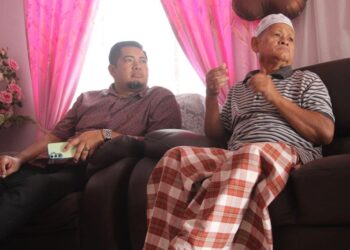 HAYAZI Azizan (kiri) turun padang bagi melawat Ketua UMNO Cawangan Putat, Ahmad Bidi (kanan) di Kampung Putat, Jerlun, Kedah, semalam.-UTUSAN