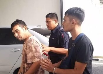 TERTUDUH, Hapizal Saad, 42, (kiri) dibawa ke Kompleks Mahkamah Kangar, Perlis, bagi menghadapi tiga pertuduhan iaitu memiliki bahan letupan, khianat dan dadah hari ini.- UTUSAN/ASYRAF MUHAMMAD