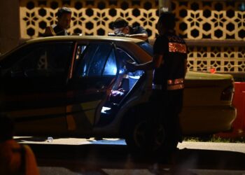 ANGGOTA polis sedang memeriksa mayat pemandu teksi yang mati dalam keretanya di Kuala Nerus, Khamis lalu. - UTUSAN/TENGKU DANISH BAHRI TENGKU YUSOFF 