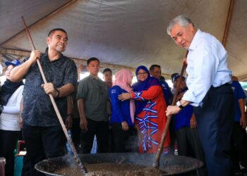 AHMAD Zahid Hamidi (kanan) mengacau bubur asyura pada Majlis Pemimpin Bersama Masyarakat Perumahan Nelayan Tok Bali, Pasir Puteh, Kelantan. - UTUSAN/KAMARUL BISMI KAMARUZAMAN 