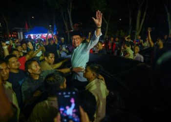 ANWAR Ibrahim (tengah) mengangkat tangan kepada penyokongnya selepas ceramah Jelajah Perpaduan Madani di PPR Hiliran, Kuala Terengganu, malam tadi.. - UTUSAN/PUQTRA HAIRRY ROSLI
