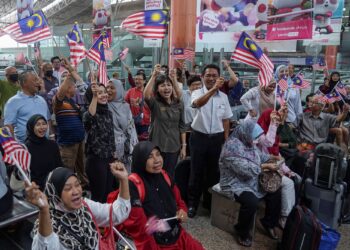 Teo Nie Ching diiringi  Mohd Rani Hisham Samsudin (berdiri kanan) mengibarkan Jalur Gemilang bersama orang awam di sekitar Lobi KL Sentral dalam  Program Pengedaran Jalur Gemilang di KL Sental, Kuala Lumpur hari ini. -UTUSAN/AMIR KHALID