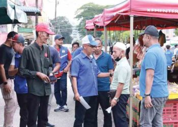 JALALUDIN Ismail (tiga dari kanan) beramah mesra dengan seorang pengunjung ketika berkempen di sebuah pasar di Kuala Berang, Hulu Terengganu, semalam.  – UTUSAN/PUQTRA HAIRRY ROSLI
