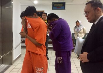MOHD. Khuzairi Shaari (dua dari kiri) yang dituduh merompak seorang peniaga dibawa keluar dari Mahkamah Sesyen Kuala Terengganu di Kuala Terengganu, hari ini. - UTUSAN/TENGKU DANISH BAHRI TENGKU YUSOFF