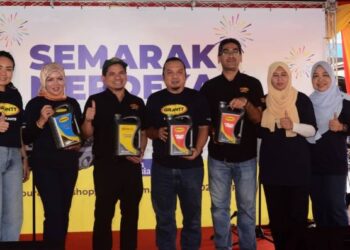 ANAS Nasrun Mohd. Osman (tiga, kiri) bersama kakitangan UMW M&E menunjukkan minyak hitam jenama Grantt dalam program Semarak Merdeka di Shah Alam, Selangor, hari ini. - UTUSAN/SYAKIR RADIN