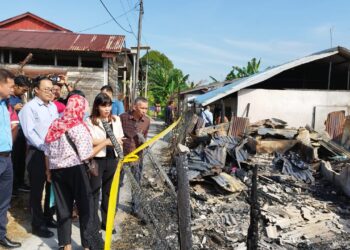TEO NIE CHING (dua dari kanan) meninjau salah sebuah rumah yang terbakar di Taman Kulai, Kulai.