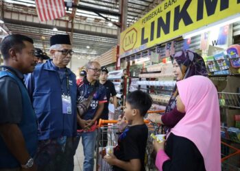 ZULKIFLI JAAFAR (kiri) mengadakan 'walkabout' di sekitar Kempas bagi mendekati pengundi Parlimen Pulai.