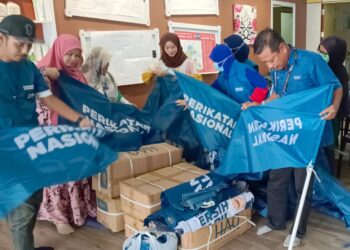 ZULKIFLI JAAFAR (kanan) membantu jenteranya memasang bendera di PDM Bukit Indah, Johor Bahru.