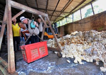 FADILLAH Yusof melihat timbangan getah ketika mengadakan lawatan ke Pusat Mengumpul Getah (PMG) Kampung Kuala Sawah, Rantau, Seremban hari ini. -UTUSAN/MOHD. SHAHJEHAN MAAMIN.
