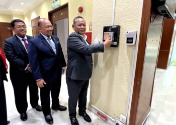 AMINUDDIN Harun meletakkan ibu jari ke mesin perakam waktu di Pejabat Menteri Besar Negeri Sembilan di Wisma Negeri, Seremban bagi memulakan tugasnya hari ini selepas dilantik ke jawatan tersebut. -UTUSAN/ZAKKINA WATI AHMAD TARMIZI