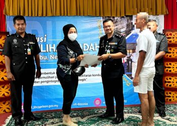 AHMAD Mustaqim Che Bisi (tiga dari kiri) menyerahkan dokumen pada majikan program PBSL Ihsan Madani (Kepulangan Yang Dinanti) Sempena Hari Kebangsaa Ke-66 di Rumah Kelab, Institusi Pemulihan Dadah Jelebu hari ini.-UTUSAN/ZAKKINA WATI AHMAD TARMIZI