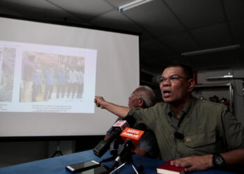 SAIFUDDIN Nasution Ismail menunjukkan gambar lawatan Muhammad Sanusi Md. Nor ketika sidang akhbar selepas walkabout bersama calon BN DUN Pedu di Pekan Naka, Padang Terap. - UTUSAN/ SHAHIR NOORDIN