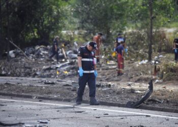 ANGGOTA polis forensik memeriksa lokasi tragedi  pesawat yang hangus terbakar selepas terhempas dan menghentam sebuah motosikal di Elmina, Seksyen U16 Shah Alam, Selangor,semalam. -UTUSAN/SADDAM YUSOFF