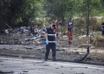 ANGGOTA polis forensik memeriksa lokasi tragedi  pesawat yang hangus terbakar selepas terhempas dan menghentam sebuah motosikal di Elmina, Seksyen U16 Shah Alam, Selangor. -UTUSAN/SADDAM YUSOFF