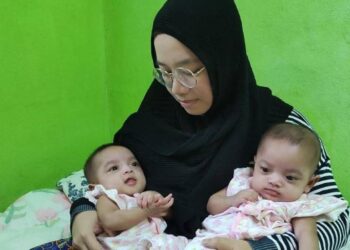ERMA Eafah Aisah Mat Napi meriba anak kembarnya di rumahnya di Kampung Tini, Pasir Hor, Kota Bharu, Kelantan.