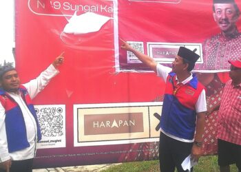 MOHD. Zawawi Ahmad Mughni (tengah) menunjukkan poster kempen PRN yang dirosakkan pihak tidak bertanggungjawab dekat Ambang Botanik di Sungai Kandis, Shah Alam, Selangor, semalam. - UTUSAN/ABDUL RAZAK IDRIS