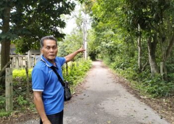 FAUZI Dollah menunjukkan laluan yang memerlukan kemudahan lampu jalan di Kampung Tok Rusa Pasir Mas, Kelantan. -UTUSAN/ROHANA ISMAIL.