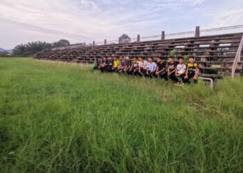 SEKUMPULAN remaja melihat keadaan padang Stadium Mini Kampung Gajah yang dinaiki semak. – UTUSAN/AIN SAFRE BIDIN