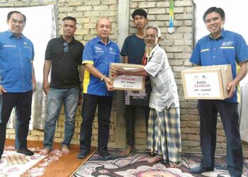 ZALIMAN Sauli (tiga dari kiri) menyampaikan surat tawaran sambung belajar dan bantuan kepada Adam Haris Abdullah (tiga dari kanan) di perumahan Keda, Bukit Kura, Kuala Nerang, Kedah semalam. – UTUSAN/IZLIZAN OTHMAN.