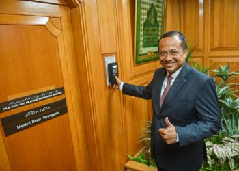 AHMAD Samsuri Mokhrae mengimbas cap jari pada alat perakam waktu ketika memulakan tugas harii pertama menjadi Menteri Besar pada penggal kedua di Wisma Darul Iman, Kuala Terengganu, hari ini. - UTUSAN/PUIQTRA HAIRRY ROSLI, 