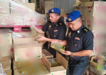 PEGAWAI KPDN Perak membuat pemeriksaan dalam serbuan di sebuah premis borong barangan runcit di Kawasan Perindustrian Ringan Kinta Jaya, Ipoh semalam. - UTUSAN