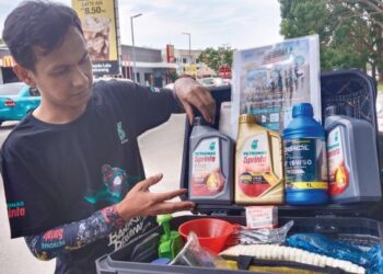 MUHAMMAD ZULHELMI Othman melalui Minyak Hitam Jalanan Melaka menawarkan perkhidmatan menukar minyak hitam secara bergerak di sekitar Melaka. - UTUSAN/MUHAMMAD SHAHIZAM TAZALI