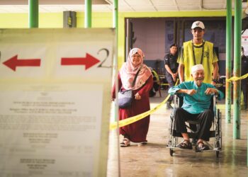 Petugas Suruhanjaya Pilihan Raya membantu warga emas ketika mengundi bagi Dewan Undangan negeri (DUN) Hulu Kelang sempena Pilihan Raya Negeri (PRN) Selangor di Sekolah Kebangsaan Klang Gates, semalam. – mingguan/MOHD. FARIZWAN HASBULLAH