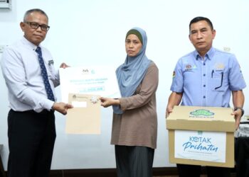 SUHAILA Akasah menerima  cek Perkeso bagi bayaran faedah pengurusan mayat yang disampaikan Roslan Pilus di Manjung, Lumut. - UTUSAN/MUHAMAD NAZREEN SYAH MUSTHAFA