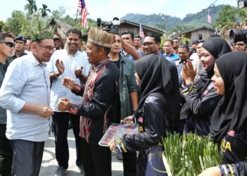 ANWAR Ibrahim (kiri) disambut penduduk ketika melawat Kampung Orang Asli Tonggang, Hulu Kinta di Ipoh. - UTUSAN/MUHAMAD NAZREEN SYAH MUSTHAFA