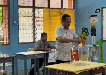 AHMAD  Samsuri Mokhtar memasukkan kertas undi ke dalam peti undi di pusat pengundian di SMK Seri Nering, Besut, hari ini.   