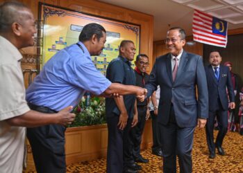 AHMAD Samsuri Mokhtar (kanan) bersalaman bersama kakitangan di Pejabat Menteri Besar di Kuala Terengganu, hari ini. - UTUSAN PUQTRA HAIRRY ROSLI