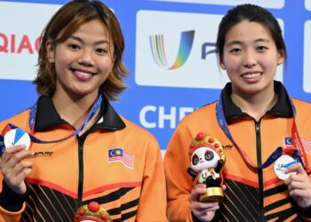 KIMBERLY Bong (kiri) dan Ong Ker Ying meraikan kejayaan memenangi pingat perak dalam Sukan Universiti Dunia di Chengdu, China hari ini.