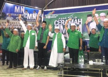 AFIQ Amani Annuar (tiga kiri) mengangkat tangan sambil memakai jaket hijau berlogo Pas semasa hadir ke ceramah Pas di Yayasan Kemiskinan Kelantan (YKK) di Melor, Kelantan di sini malam tadi-UTUSAN/ROSMIZAN RESDI
