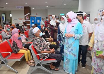 ZALIHA Mustafa (dua dari kanan) bertanyakan sesuatu kepada seorang pesakit yang menerima rawatan Klinik Kesihatan Manir, Kuala Terengganu, hari ini. - UTUSAN/PUQTRA HAIRRY ROSLI
