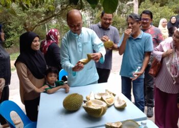 FAIRUL Nizam Roslan melayani pengamal media sewaktu Program Ramah Mesra Media dan Makan Durian di sebuah dusun di Kampung Ayer Pasir, Selandar, Melaka. - UTUSAN/AMRAN MULUP