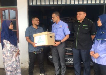 DR. Mohammed Azman Aziz Mohammed (tiga, kanan) menyerahkan replika tajaan peralatan bengkel Tengku Mohamad Amirul Akmal menerusi Program Cakna Prihatin di Kampung Hutan Banggol, Kota Bharu, Kelantan hari ini-UTUSAN/ROSMIZAN RESDI