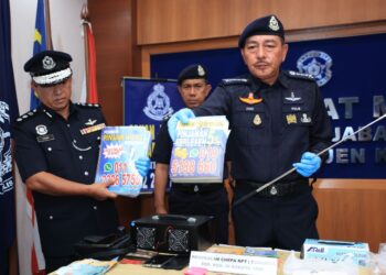 MUHAMAD Zaki Harun (kanan) menunjukkan kertas iklan berkait dengan pinjaman ah long yang dirampas pihaknya semasa sidang media di Ibu Pejabat Polis Kontinjen Kelantan (IPK) Kelantan di Kota Bharu, Kelantan hari ini-UTUSAN/KAMARUL BISMI KAMARUZAMAN