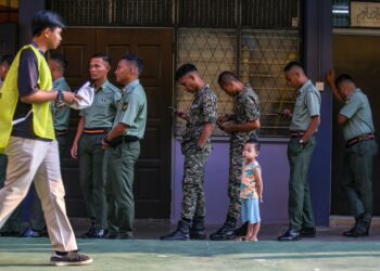 SEORANG kanak-kanak menemani bapanya yang bertugas sebagai anggota tentera ketika proses pengundian awal PRN Kedah di Kem Lapangan Terbang, Sungai Layar di Sungai Petani. - UTUSAN/ SHAHIR NOORDIN