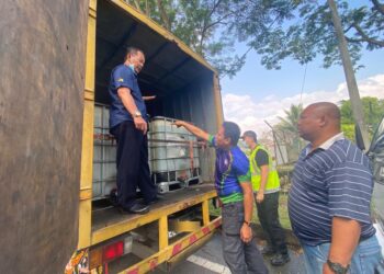ANGGOTA penguat kuasa KPDN Negeri Sembilan memeriksa tangki IBC berisi minyak diesel yang berada di dalam lori ketika serbuan Op Tiris di Taman Seremban Jaya, Seremban, semalam.
