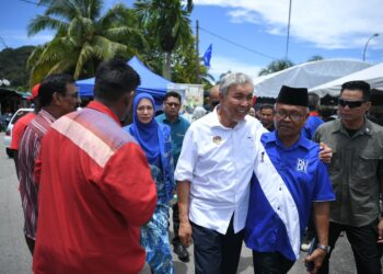 AHMAD Zahid Hamidi (tengah) beramah mesra dengan seorang penduduk selepas merasmikan Program Desa Cerdas Jabatan Kemajuan Masyarakat (Kemas) di Taman Nilam, Kuah di Langkawi.