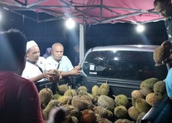 PELANGGAN membeli durian yang dijual di atas kenderaan pacuan empat roda di halaman rumah penduduk di Kampung Matang Merbau, Bagan Serai - UTUSAN/WAT KAMAL ABAS