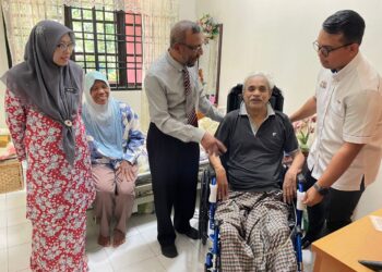 ZULKIFLI Hanifah (tiga dari kiri) menyerahkan sumbangan kerusi roda kepada seorang pesara di Merlimau, Jasin, Melaka.