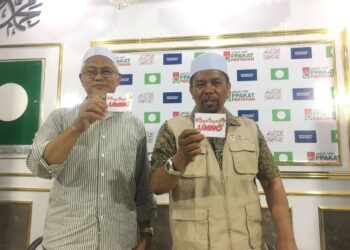 WAN Roslan Wan Hamat (kanan) melihat pelekat 'Bye-Bye UMNO' pada sidang akhbar harian Perikatan Nasional (PN) di Pejabat Perhubungan Pas Negeri Kelantan, di Kota Bharu, Kelantan. UTUSAN/ROSMIZAN RESDI