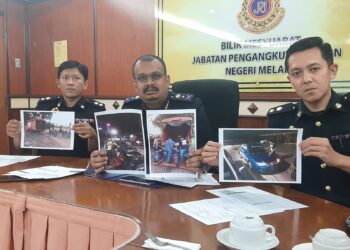 MUHAMMAD FIRDAUS Shariff (tengah) menunjukkan foto anggota JPJ menyita motosikal dalam sidang akhbar di Ibu Pejabat JPJ negeri di Bukit Katil, Melaka. - UTUSAN/AMRAN MULUP
